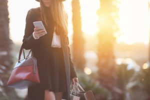 Shot of a woman using her phone while shopping in a boutique
